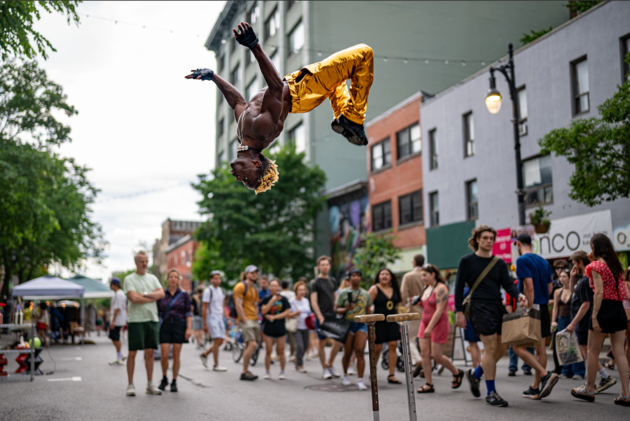 A street performer turning in the air above a Montréal crowd