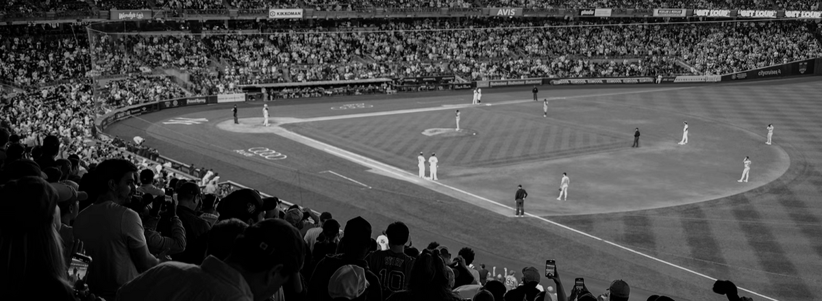 Black-and-white documentary view of Yankee Stadium, with players on the field and fans in the stands